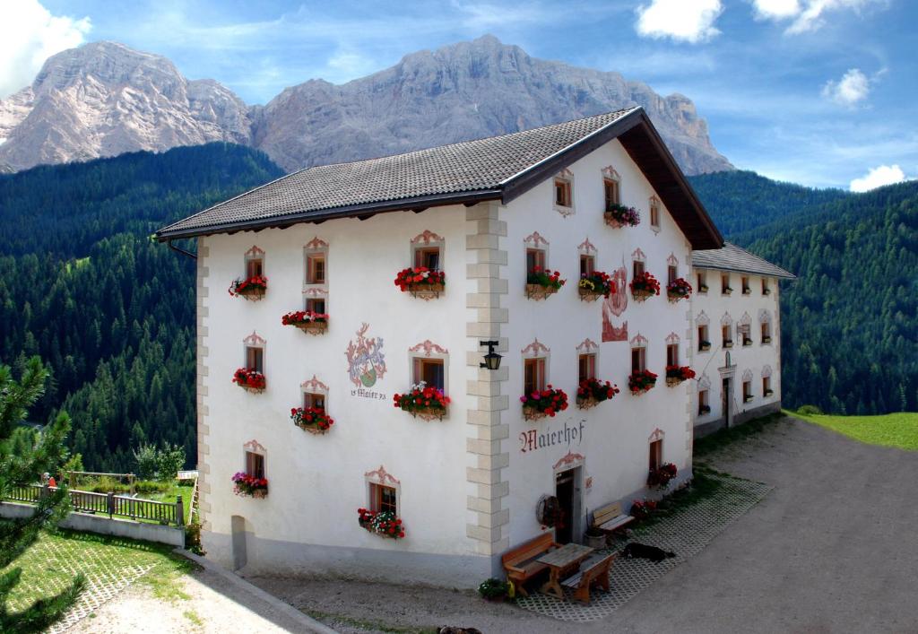 un edificio con flores a un lado. en Appartamenti Maierhof, en La Valle