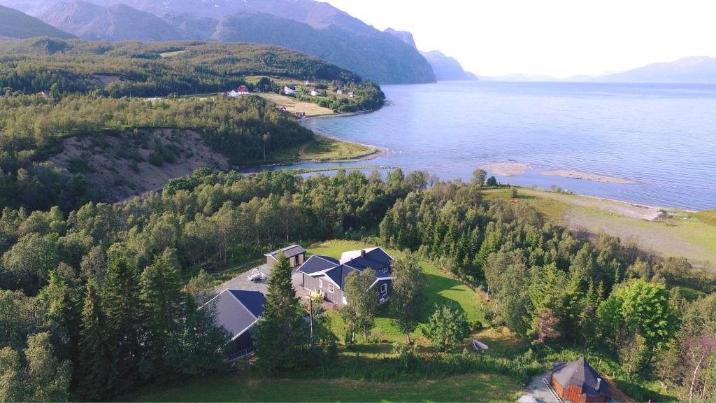 an aerial view of a house on an island in the water at House in the heart of the Lyngen Alps with Best view in Lyngseidet