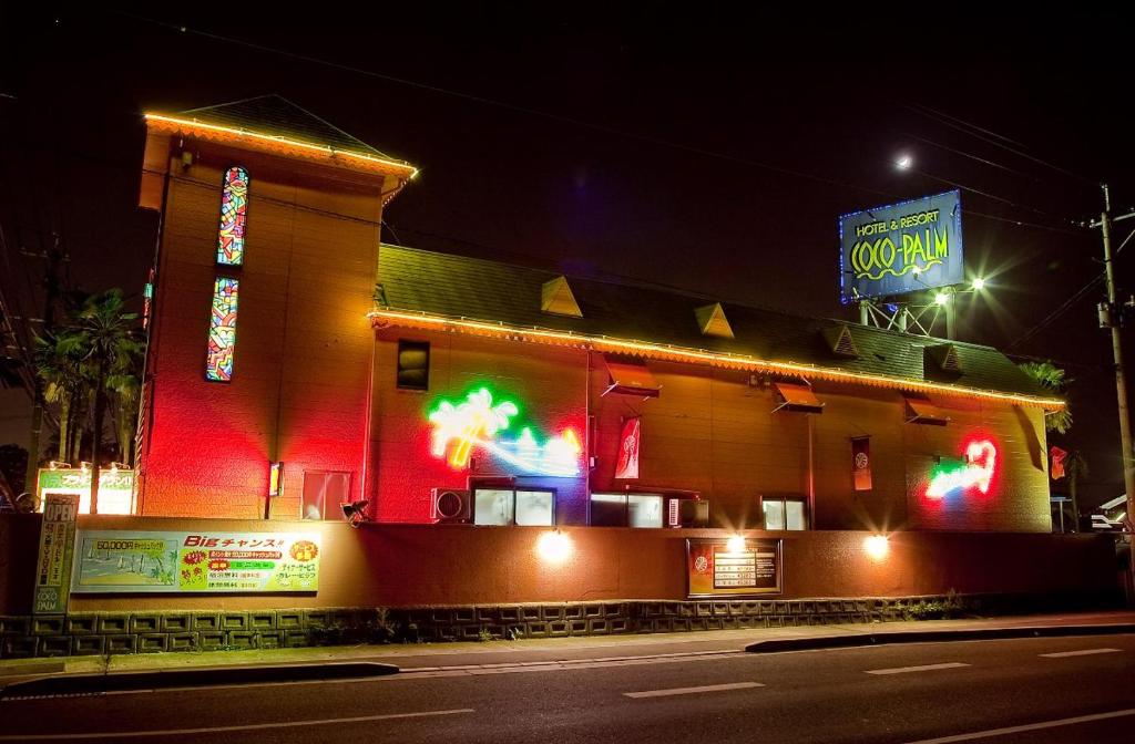 un restaurante de comida rápida con luces de neón en una calle en Hotel Coco-Palm (Love Hotel), en Tosu