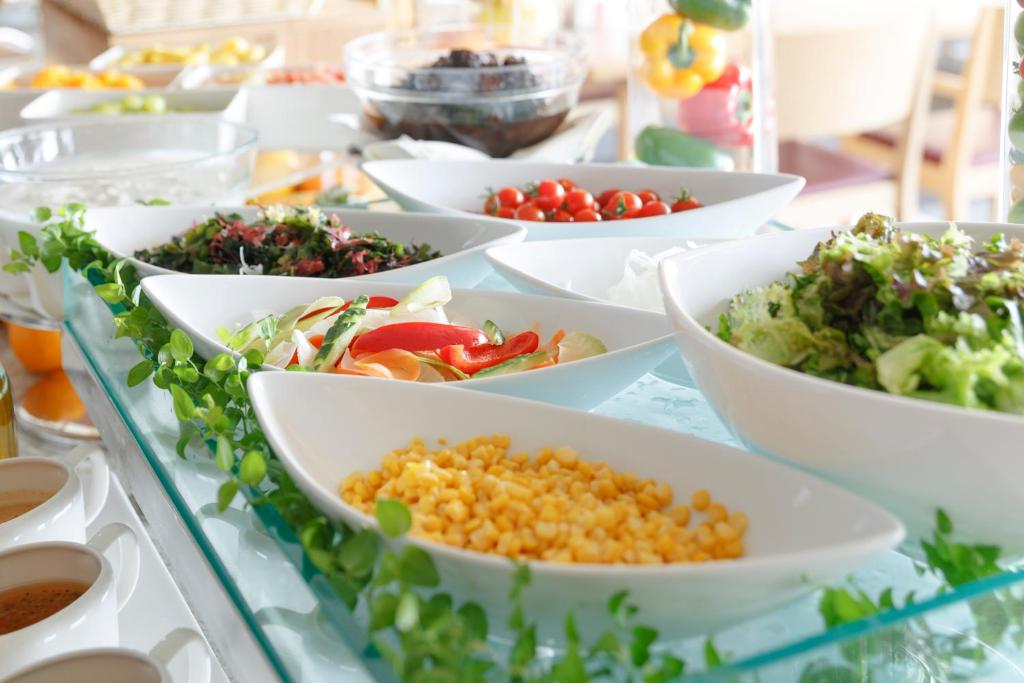 a buffet filled with bowls of different types of food at Haneda Excel Hotel Tokyu Haneda Airport Terminal 2 in Tokyo
