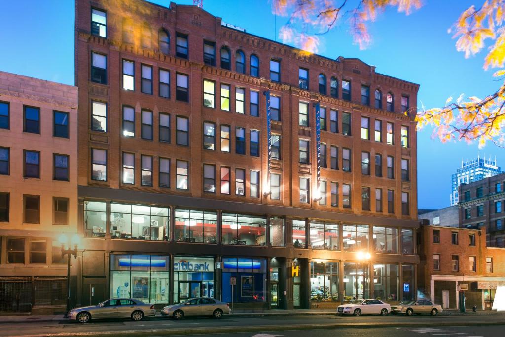 un grand bâtiment en briques avec des voitures garées devant lui dans l'établissement HI Boston Hostel, à Boston