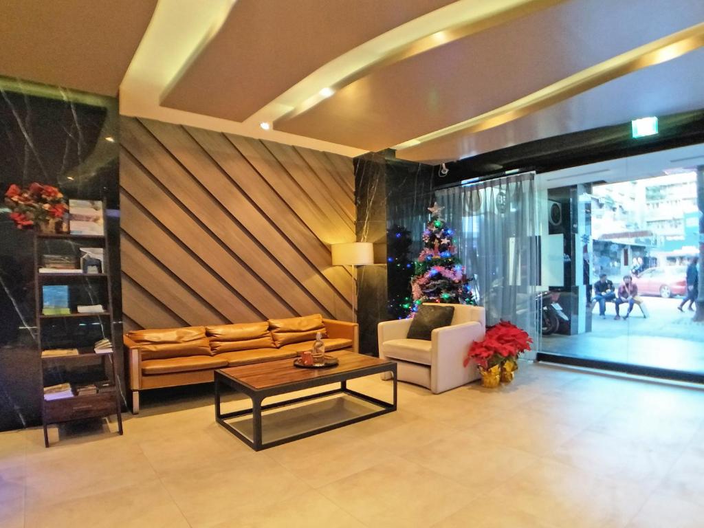 a living room with a couch and a christmas tree at Beauty Hotels Taipei - Hotel B6 in Taipei