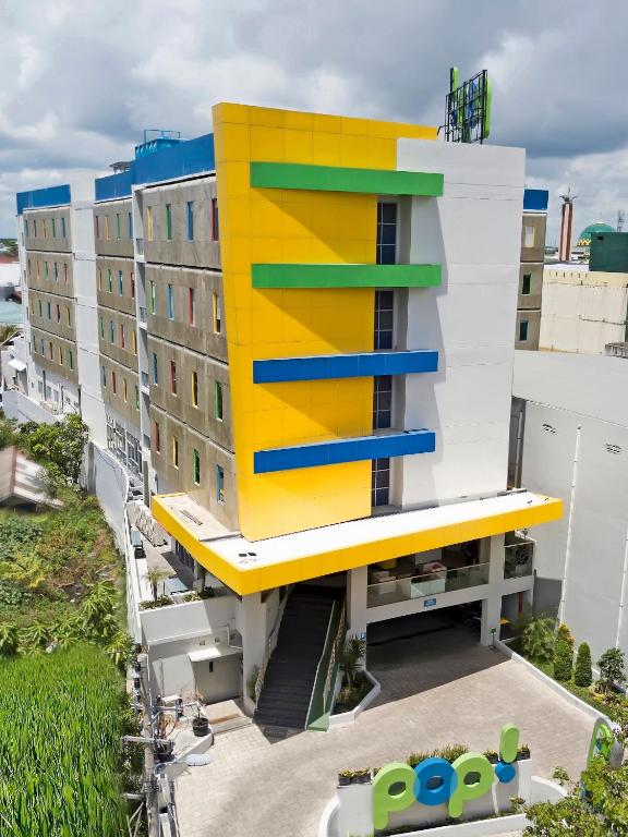 a building with a yellow and blue at POP! Hotel Banjarmasin in Banjarmasin
