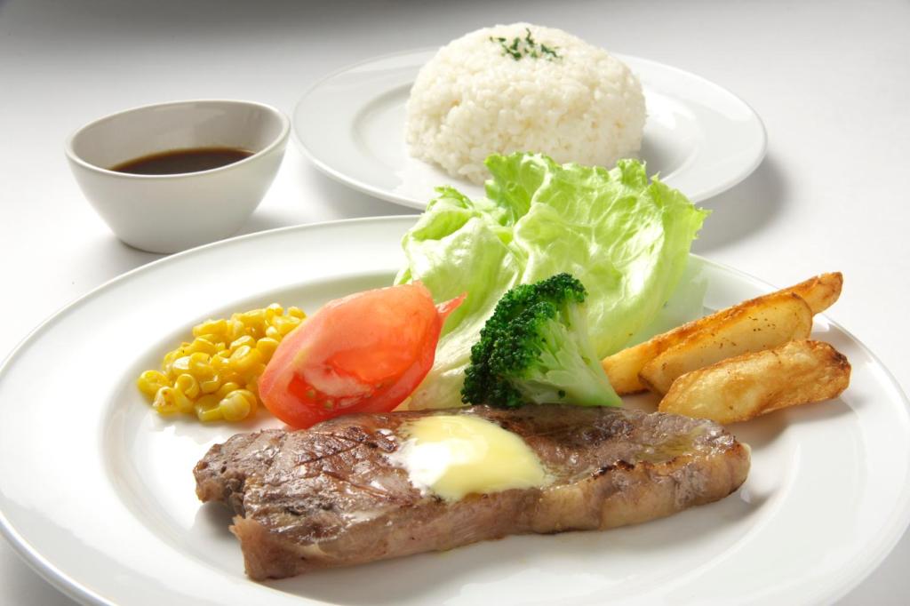 un plato de comida con carne y verduras en una mesa en Hotel Coco de Annex (Love Hotel), en Kitakyushu