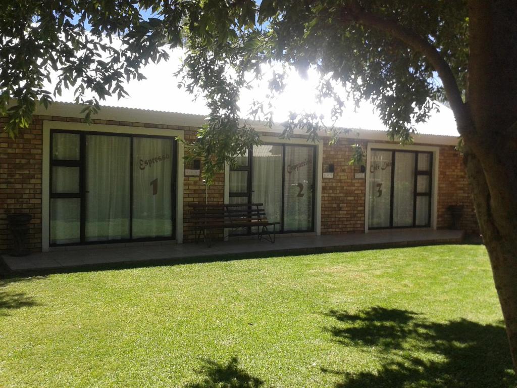 a brick building with a bench in the yard at Coffee@Home (Pty) Ltd in Prieska