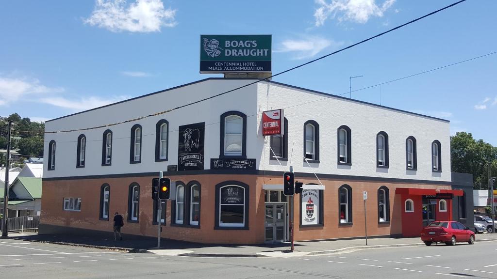 a building with a sign on top of it on a street at Centennial Inn on Bathurst in Launceston