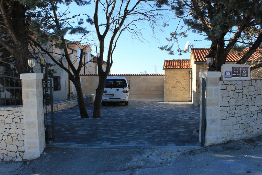 a white van parked in a driveway next to a fence at Guest house Ivo in Donji Humac