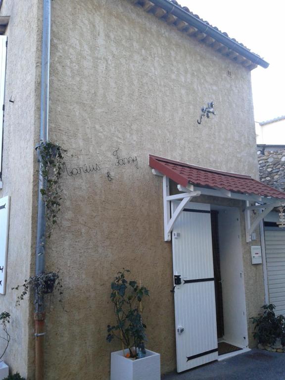 un bâtiment avec une porte blanche et un toit rouge dans l'établissement Marius et Fanny, à Oraison