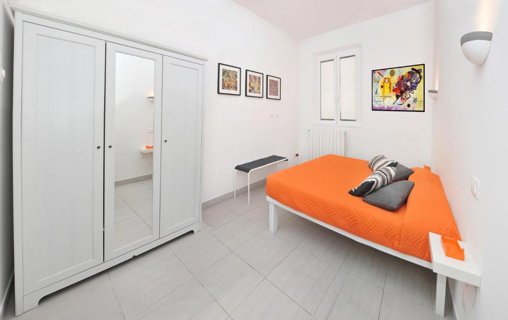 ローマにあるApartment Close To Vatican Museums And To Metroのベッドルーム(オレンジ色のベッド1台、ウォークインクローゼット付)