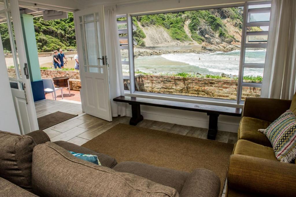 Silver Spray Beach Accommodation في خليج فيكتوريا: غرفة معيشة مطلة على الشاطئ