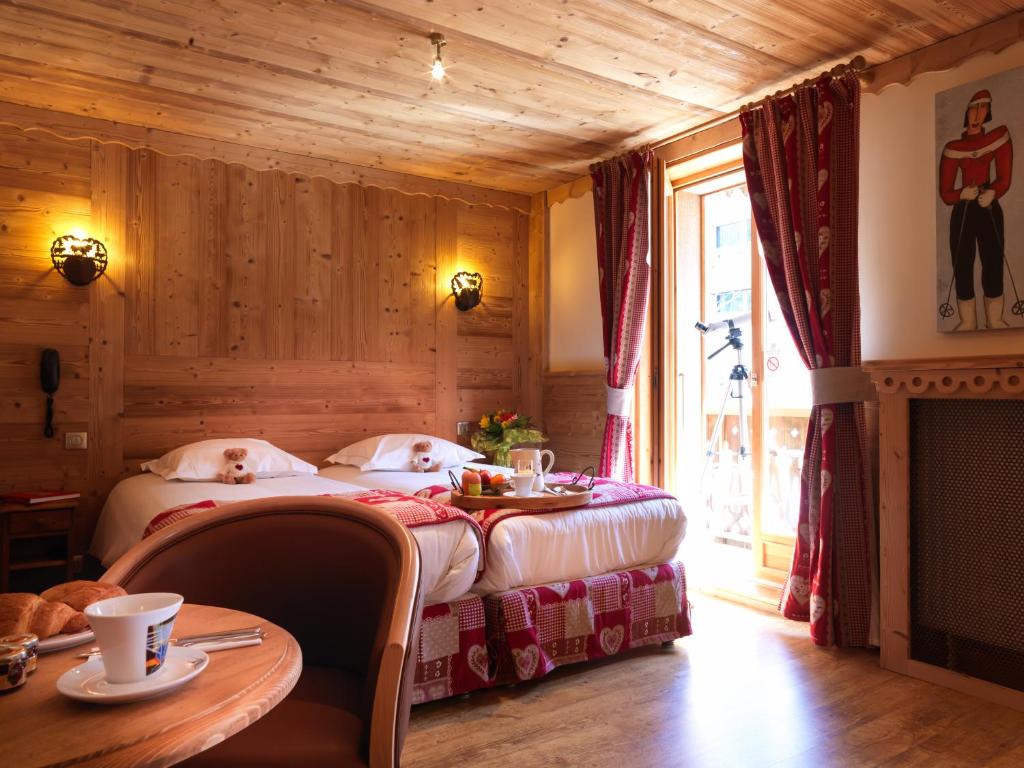 a bedroom with a bed with two dogs on it at Auberge du Manoir in Chamonix