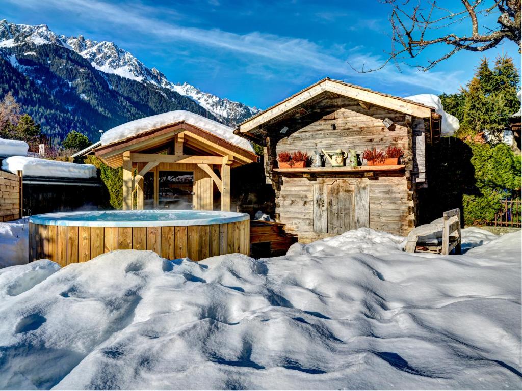 a log cabin in the snow with a hot tub at Auberge du Manoir in Chamonix