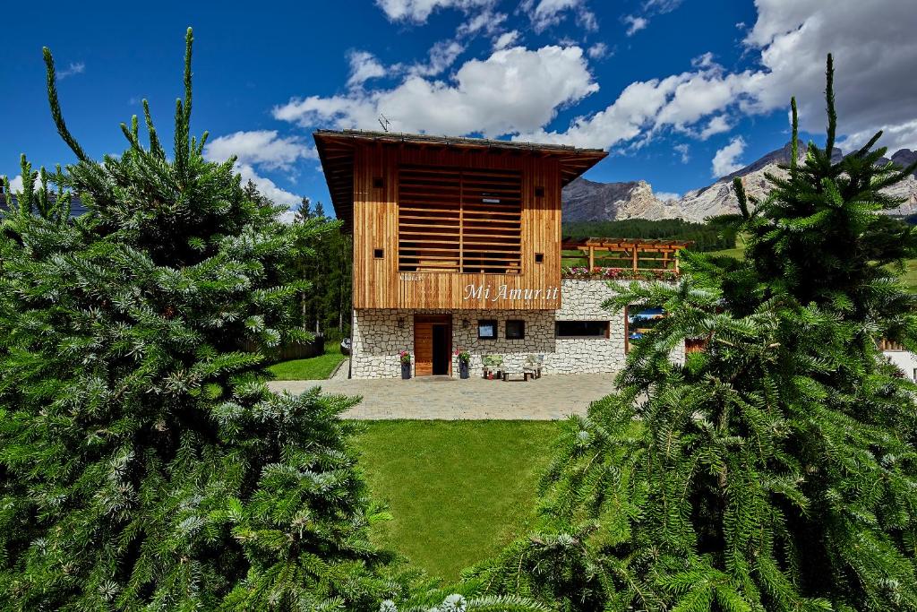 a building in the middle of two pine trees at Chalet Mi Amur in La Villa