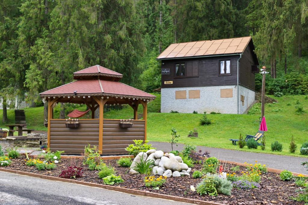 einen Garten mit einem Pavillon vor einem Haus in der Unterkunft Chaty Studienky in Oravský Biely Potok