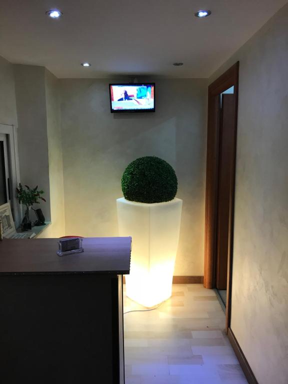 un soggiorno con tavolo e TV a parete di Hotel Tokyo a Roma