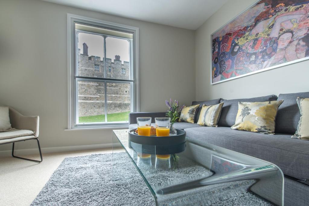 a living room with a couch and a glass table at Central Windsor Apartment Facing the Castle in Windsor