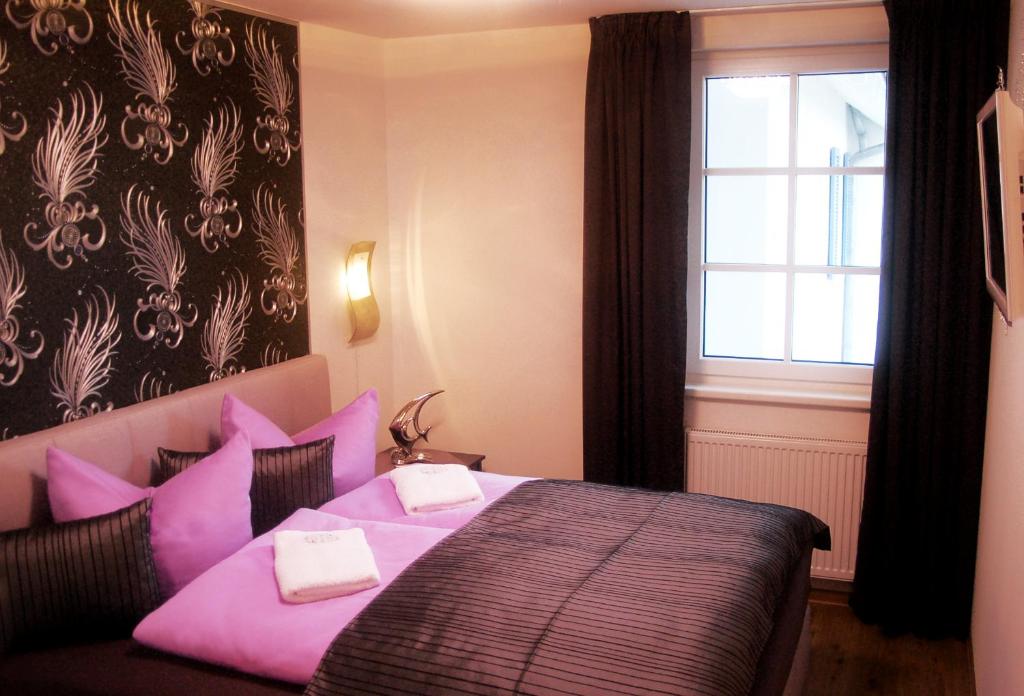 巴貝的住宿－Sun Island，一间卧室配有带粉红色枕头的床和窗户。