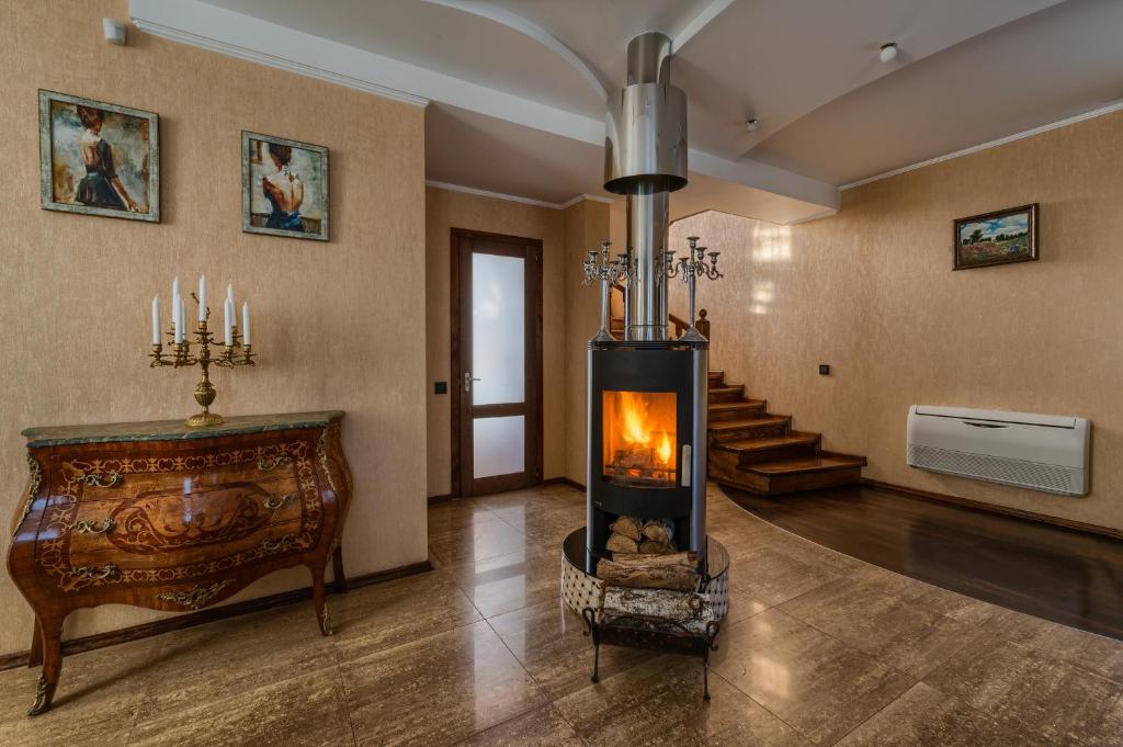 a living room with a fireplace in the middle at Villa de Jardin in Svyatopetrivske