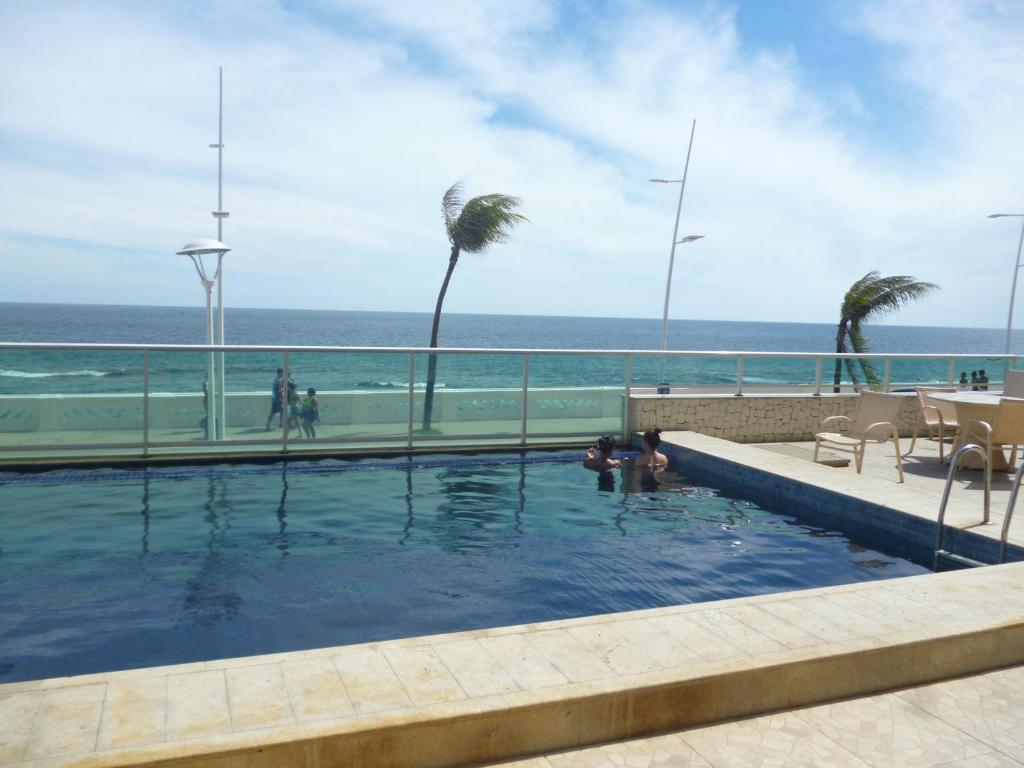 a swimming pool with a view of the ocean at Bahia Flat 117 in Salvador