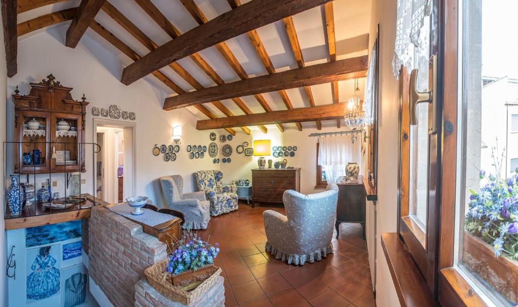 フェラーラにあるPiccola Casa Anticaの木製の天井と青い椅子が備わるリビングルーム