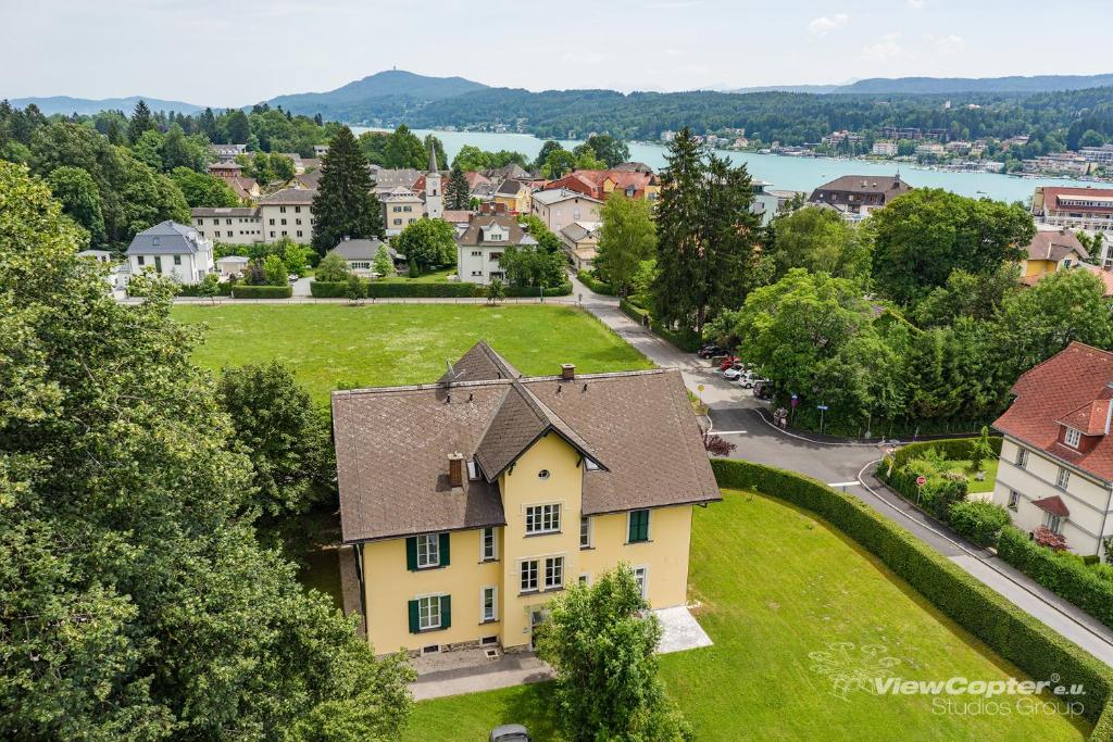 an aerial view of a town with a yellow house at Villa Engstler - Appartments in Velden am Wörthersee