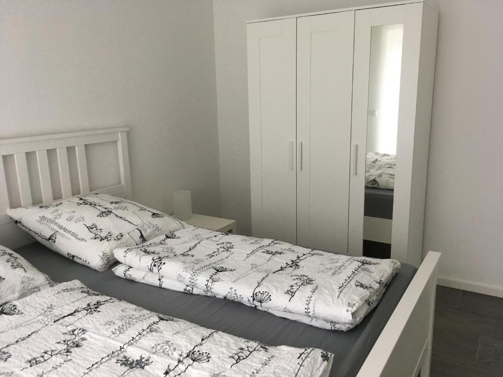 ノイシュタット・アム・リューベンベルゲにあるFerienwohnung Angelikaのベッドルーム1室(ベッド2台、白いキャビネット付)