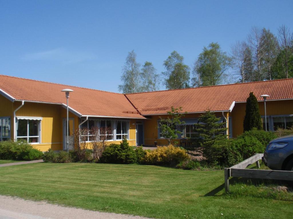 a yellow house with a red roof at Örtagården in Uddevalla