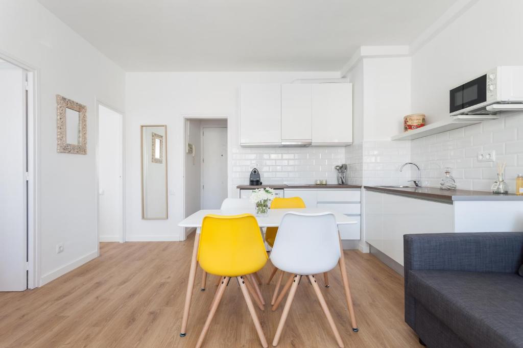 a kitchen with a table and two yellow chairs at Flateli Providencia in Barcelona