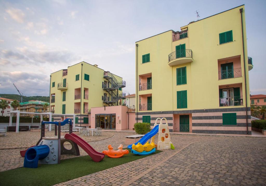 un parque infantil frente a un edificio con un edificio en Residence Le Saline, en Borgio Verezzi