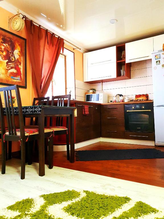 a kitchen with a table and a kitchen with a refrigerator at Apartment Ushakova 16 in Dnipro
