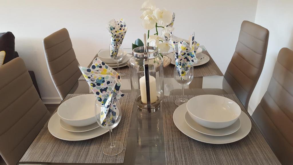 a dining room table with plates and dishes on it at Flemming Place in East Kilbride