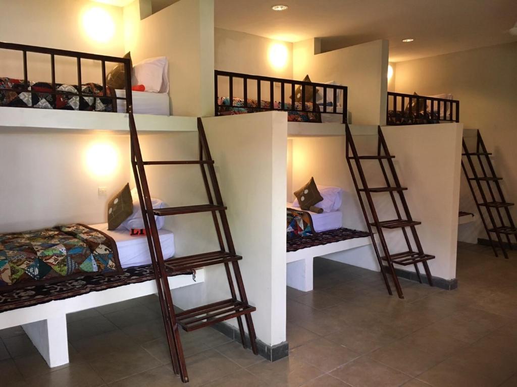 a room with three bunk beds in a room at Pebble & Fins Bali Dive Resort in Tulamben