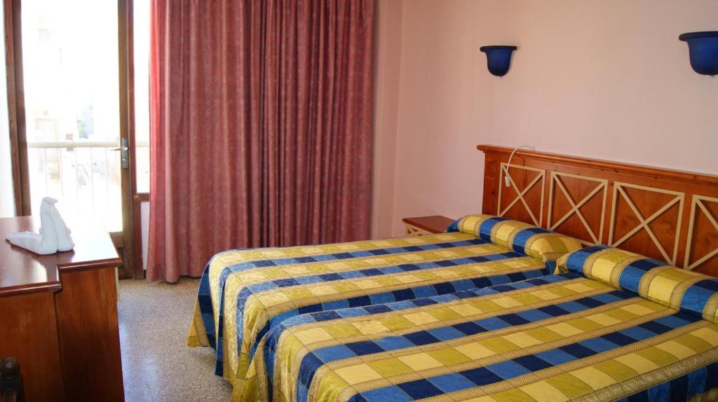 A bed or beds in a room at Hotel Alfonso