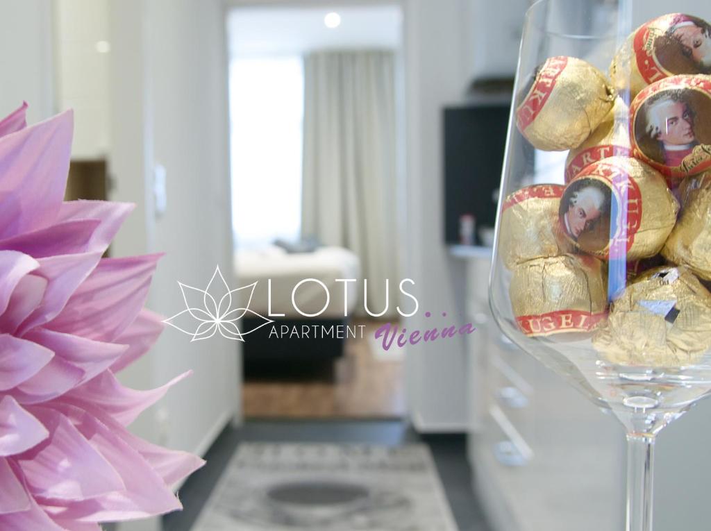 ウィーンにあるLotus Apartment Viennaのクッキー入りワイングラスとピンクの花