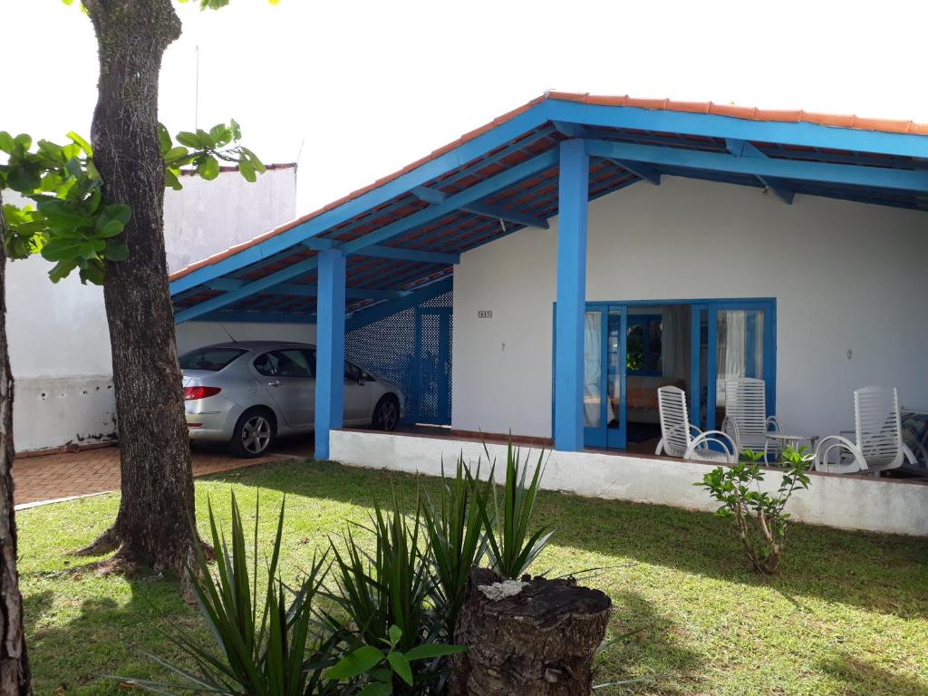 une maison avec une voiture garée devant elle dans l'établissement Casa perto da praia, à Itanhaém