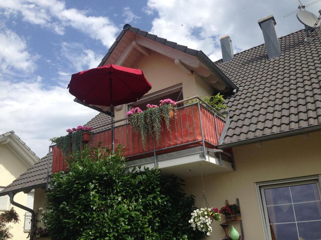 a balcony with an umbrella on a house at Ferienwohnung Haus Albsicht in Mössingen