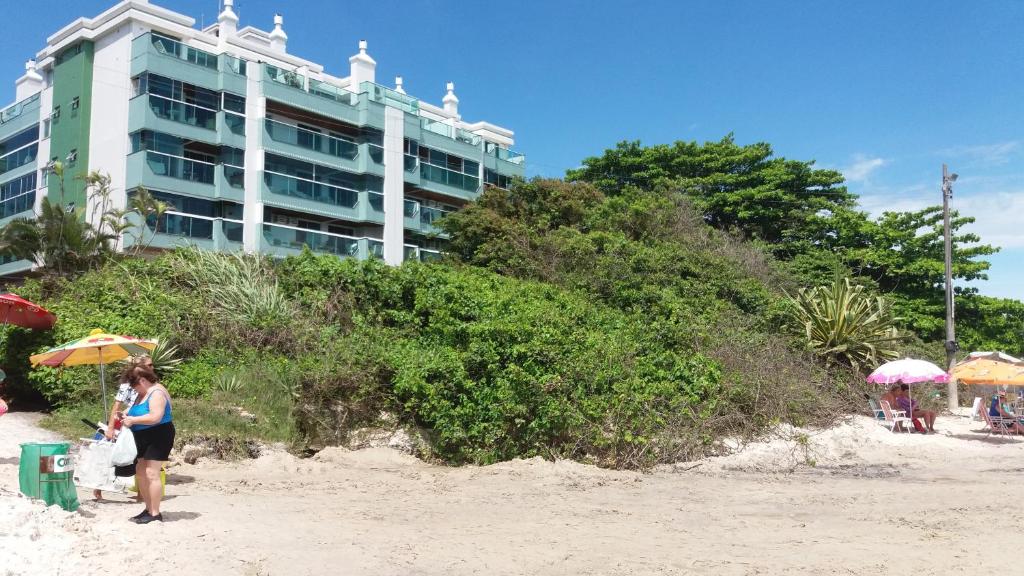 una mujer parada en la playa frente a un hotel en Morada do Barão, en Florianópolis