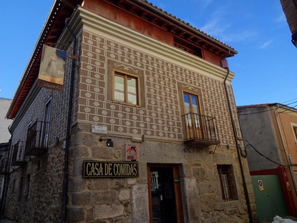 un viejo edificio de ladrillo con un cartel. en Hotel Rural Cayetana en Piedrahita