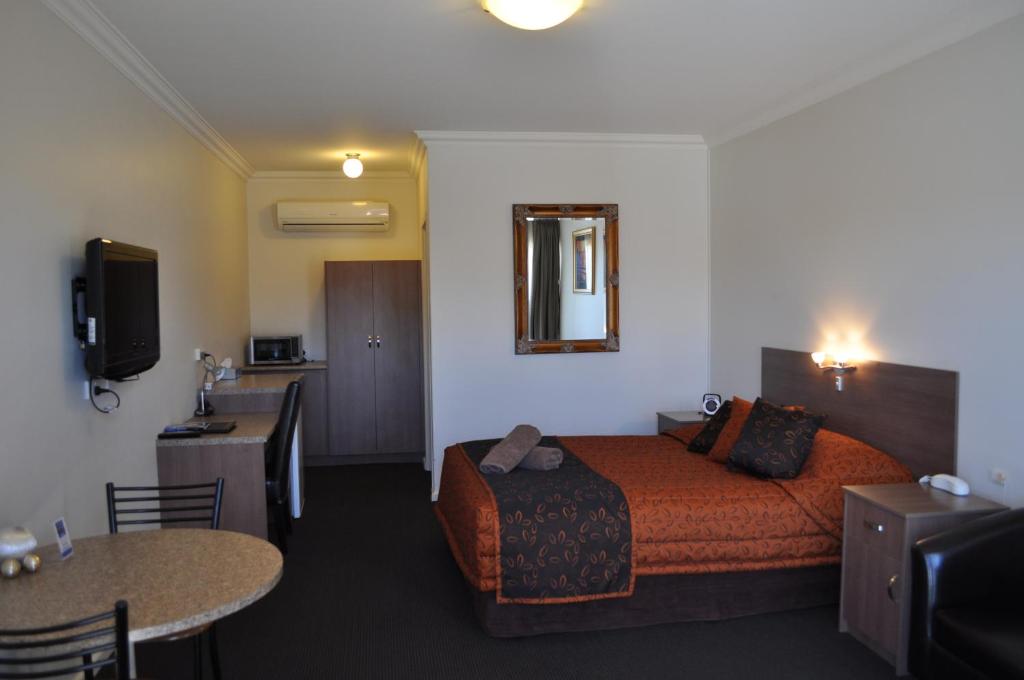
a hotel room with a bed and a television at Augusta Courtyard Motel in Port Augusta
