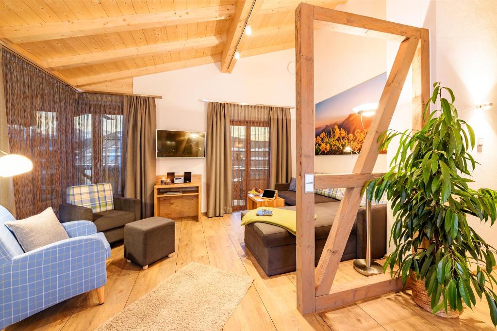 ein Wohnzimmer mit einem blauen Sofa und einem blauen Stuhl in der Unterkunft Casatina Ferienwohnungen in Oberstdorf