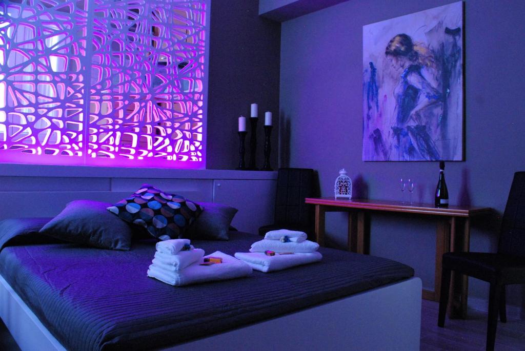 ローマにあるCostantino Terzo Residenceの紫色のベッドルーム(ベッド1台にタオル2枚付)