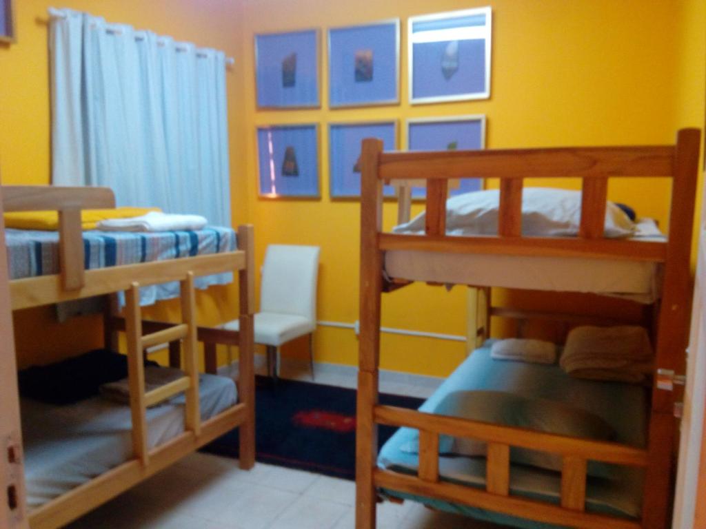 a room with two bunk beds and a yellow wall at Mini Hostel Fine Art in Vitória da Conquista