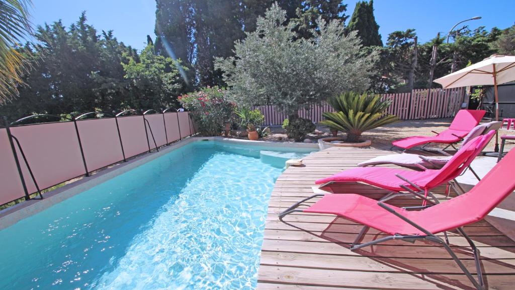 una terraza con sillas y una piscina en Mas Garonnette, en Sainte-Maxime