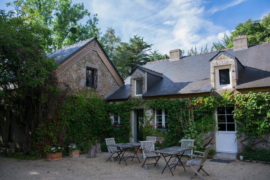 a house with a table and chairs in front of it at Manoir des Eperviers in Quéven