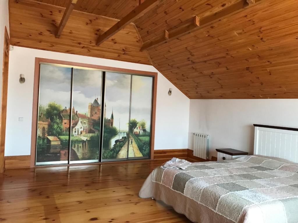 um quarto com uma grande janela e uma cama em Приватний будинок для сімейного відпочинку з басейном і сауною em Grigorʼyevka