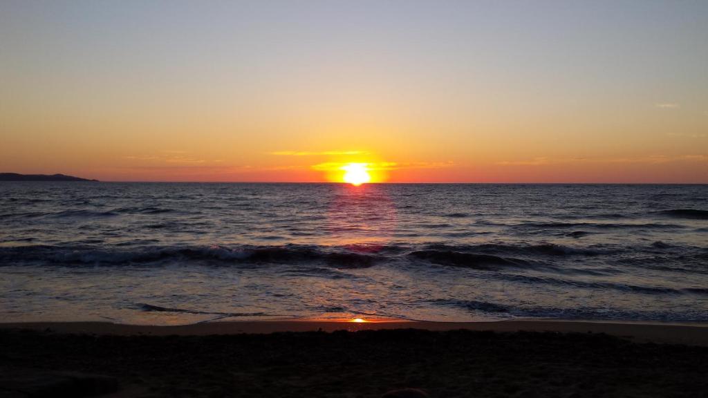 a sunset on the beach with the ocean at Chambre d'hôtes à 5mn des plages in Patrimonio