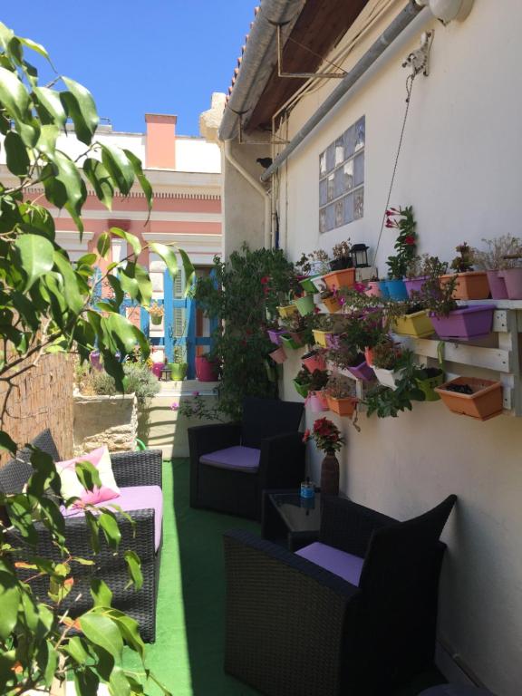 un patio con sedie e piante in vaso su un edificio di MmeBassia a Chania