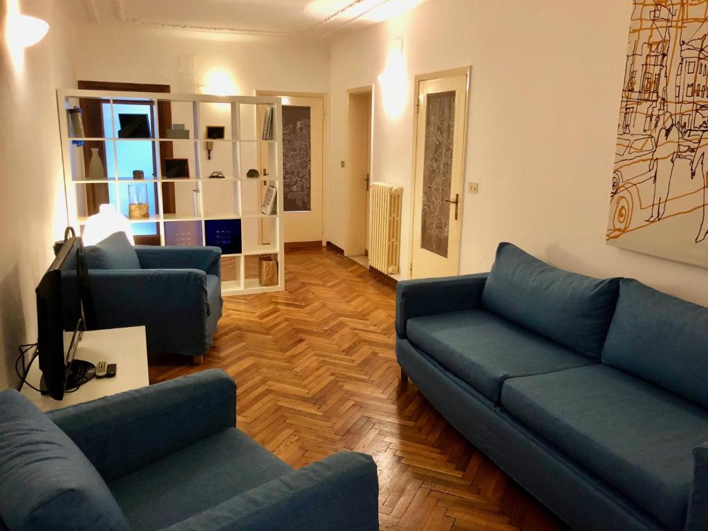 un soggiorno con 2 divani blu e una TV di Cà Giulia a Venezia