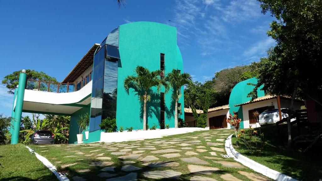 un edificio azul con palmeras delante en Brava Guest House Búzios, en Búzios