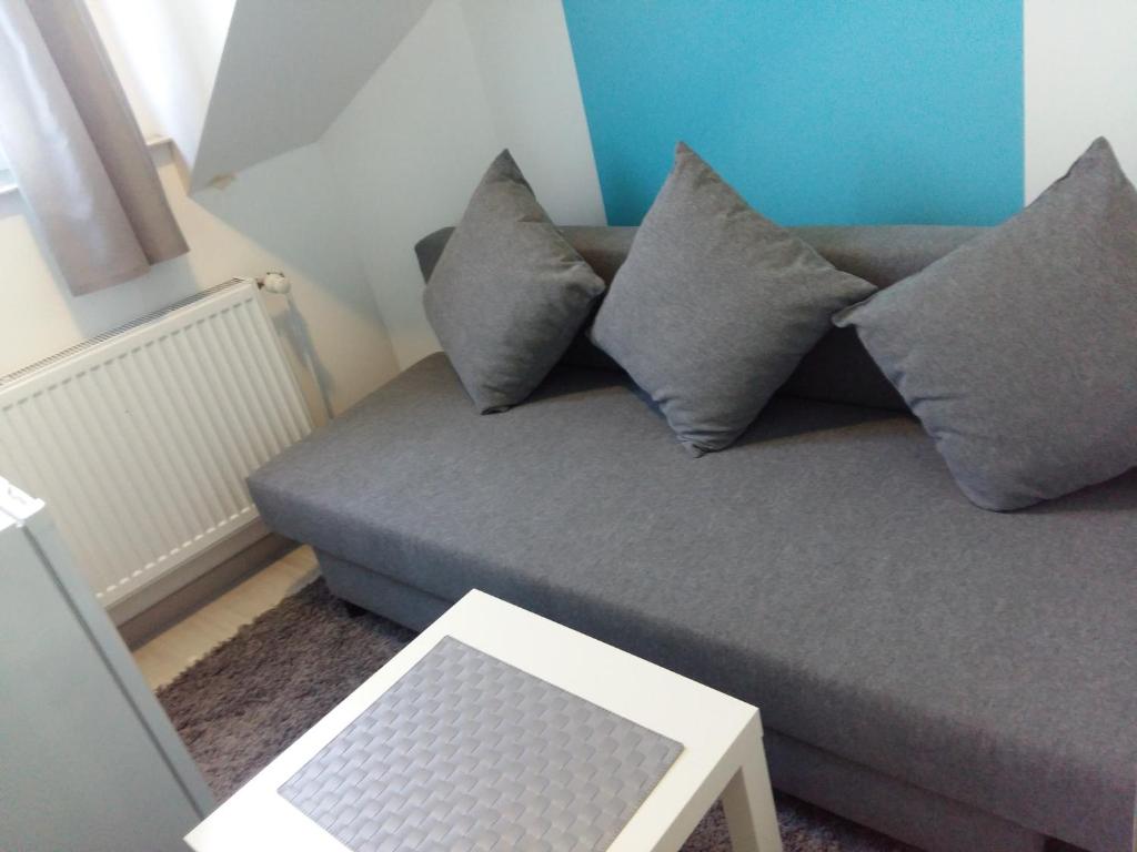 un sofá gris con almohadas en la sala de estar en Private Studio Brussels Airport en Bruselas